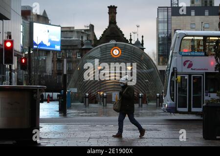 Una donna passa davanti all'ingresso della stazione della metropolitana su Buchanan Street, Glasgow, la mattina dopo che sono entrate in vigore misure di blocco più severe per la Scozia continentale. Foto Stock