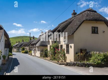 Fila di belle case tradizionali con tetto di paglia sulla strada principale a West Lulworth in Dorset, Inghilterra, Regno Unito Foto Stock