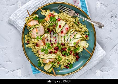 Spiedini di salmone e zucchine con couscous al limone e semi di melograno - vista dall'alto Foto Stock