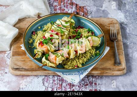 Spiedini di salmone e zucchine con couscous al limone e semi di melograno Foto Stock