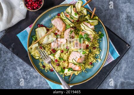 Spiedini di salmone e zucchine con couscous al limone e semi di melograno - vista dall'alto Foto Stock