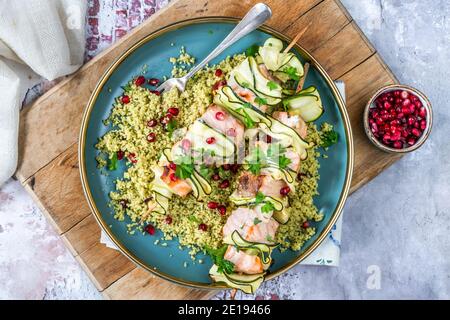 Spiedini di salmone e zucchine con couscous al limone e semi di melograno - vista dall'alto Foto Stock