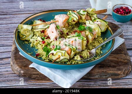 Spiedini di salmone e zucchine con couscous al limone e semi di melograno Foto Stock