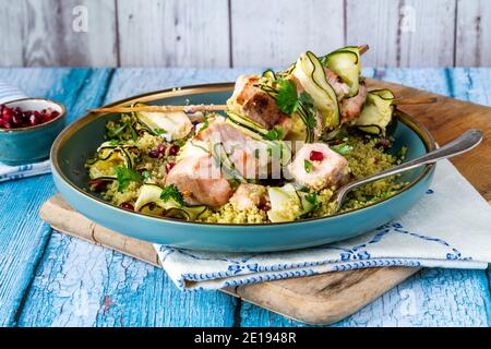 Spiedini di salmone e zucchine con couscous al limone e semi di melograno Foto Stock