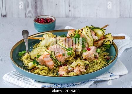 Spiedini di salmone e zucchine con couscous al limone e semi di melograno Foto Stock