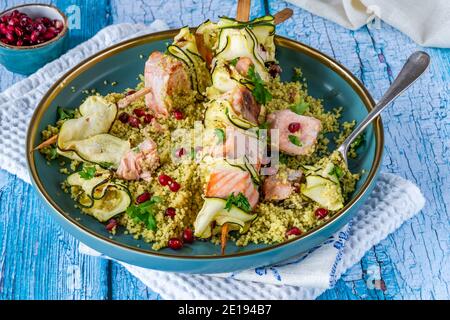 Spiedini di salmone e zucchine con couscous al limone e semi di melograno Foto Stock