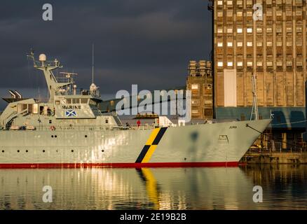 MPV Jura, nave di protezione marina per la pesca del governo scozzese e silo di grano industriale con riflessi, Imperial Dock, Leith, Edimburgo, Scozia, Regno Unito Foto Stock