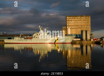 MPV Jura, nave di protezione marina per la pesca del governo scozzese e silo di grano industriale con riflessi, Imperial Dock, Leith, Edimburgo, Scozia, Regno Unito Foto Stock