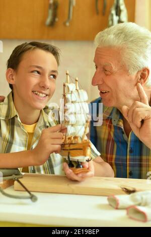Carino il ragazzo con il nonno rendendo modello in legno Foto Stock