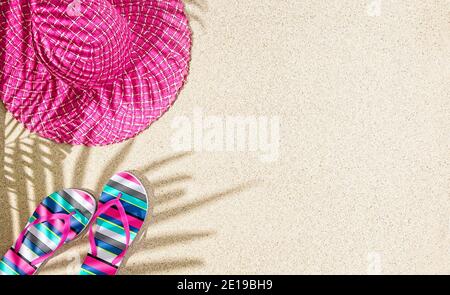 Cappello rotondo grande estate rosa e sandali colorati a righe su sabbia con l'ombra delle palme Foto Stock