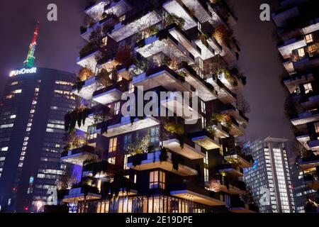 Bosco verticale, foresta verticale, condominio moderno con alberi che crescono su balconi, architettura sostenibile, vista notturna. UniCredit torre. Foto Stock