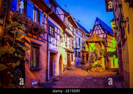 Il piccolo villaggio feudale di Eguisheim durante l'ora blu. Foto scattata il 10 agosto 2019 nella regione dell'Alsazia in Francia. Foto Stock