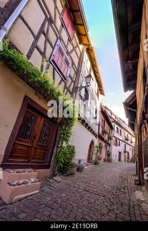 La piccola strada feudale villaggio di Eguisheim durante il giorno. Foto scattata il 10 agosto 2019 nella regione dell'Alsazia in Francia. Foto Stock