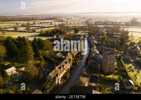Foto aerea di un villaggio di Cotswolds, campi e paesaggi di campagna inglese con case, proprietà e immobili nel mercato immobiliare del Regno Unito, Bourton on the Hill, Gloucestershire, Inghilterra Foto Stock