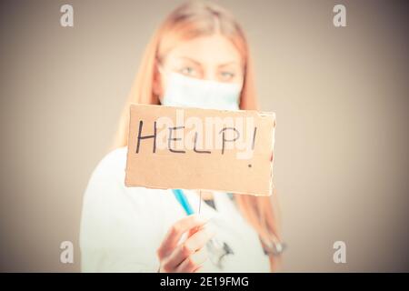 Un medico che tiene un aiuto segno da vicino isolato Foto Stock