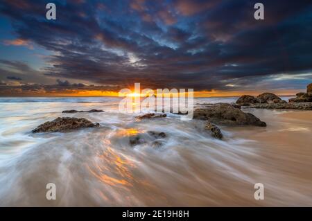 Moody Tramonto sulla costa meridionale dell'Algarve in Portogallo Foto Stock