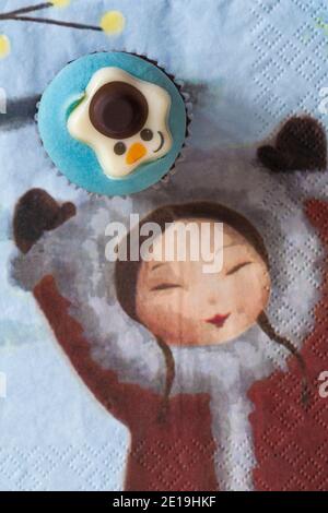 Torta di coppe Snowman da scatola di M&S 9 mini Festive cupcakes set su Natale serviette tovagliolo Xmas con la ragazza tenere le mani in alto Foto Stock