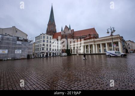 Schwerin, Germania. 05 gennaio 2021. Solo pochi passanti si trovano sulla piazza del mercato di fronte alla Cattedrale di Schwerin. Il Cancelliere e i Minister-Presidenti degli Stati federali discutono di un'estensione del blocco per contenere la pandemia di Corona. Credit: Jens Büttner/dpa-Zentralbild/dpa/Alamy Live News Foto Stock