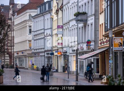 Schwerin, Germania. 05 gennaio 2021. Solo pochi passanti si trovano sulla strada principale dello shopping nella capitale dello stato. Il Cancelliere e i Presidenti del Ministro degli stati federali discutono di un ampliamento della chiusura per contenere la pandemia di Corona. Credit: Jens Büttner/dpa-Zentralbild/dpa/Alamy Live News Foto Stock