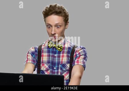 Un ragazzo scioccato che guarda al tablet digitale. Foto Stock