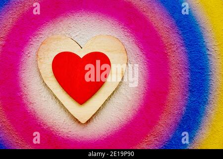 San Valentino sfondo con cuori in legno su sfondo colorato in cemento, vista dall'alto. Concetto di giorno di San Valentino Foto Stock