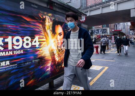 Hong Kong, Cina. 12 dicembre 2020. Un pedone cammina accanto a un cartellone pubblicitario dal sito ufficiale di Warner Bros e DC fums personaggio Wonder Woman 1984 film a Hong Kong. Credit: Budrul Chukrut/SOPA Images/ZUMA Wire/Alamy Live News Foto Stock