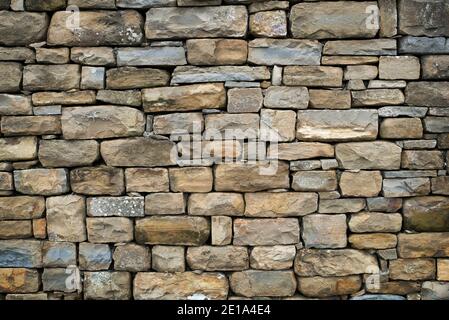 La texture di un muro di pietra. Il castello vecchio muro di pietra la texture dello sfondo. Muro di pietra come sfondo o texture. Parte di un muro di pietra, per sfondo o del testo Foto Stock