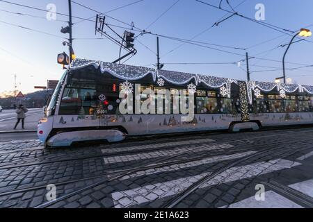 PRAGA - 30 dicembre: Tram Skoda 15T con decorazioni natalizie e luci nella vicina neigborhood del Teatro Nazionale il 30 dicembre 2020 a Praga, Foto Stock