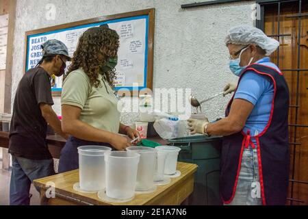 Attraverso un sistema di numerazione, a tutte le persone che necessitano di cibo viene assegnato un numero, e poi rimosso dalla loro fornitura alimentare. Il piatto della solidarietà è un pr sociale Foto Stock