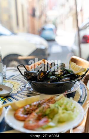 Piatti di pesce e pesce di vongole, conchiglie, cozze e gamberi fritti e crudi Foto Stock