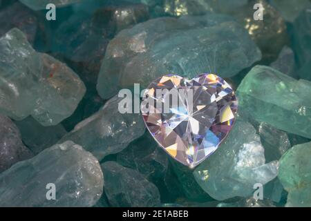 primo piano diamante a forma di cuore messo su blu cielo grezzo gemme Foto Stock
