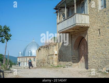 Una vecchia casa in Anig, Qusar distretto, Azerbaigian. Ci sono poche vecchie case ad Anig. Questi edifici hanno grandi cancelli di legno; presumibilmente, sono stati utilizzati per tenere cavalli. La gente usa solo la piccola porta nei cancelli e non apre mai i cancelli poichè non hanno più cavalli. Tali case hanno 2 piani, come tutte le case tradizionali nei villaggi di montagna nel quartiere di Qusar. Il primo piano è utilizzato per immagazzinare prodotti e conservare pollame, il secondo piano è un luogo di soggiorno. Foto Stock