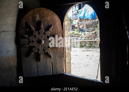 Una vecchia casa in Anig, Qusar distretto, Azerbaigian. Ci sono poche vecchie case ad Anig. Questi edifici hanno grandi cancelli di legno; presumibilmente, sono stati utilizzati per tenere cavalli. La gente usa solo la piccola porta nei cancelli e non apre mai i cancelli poichè non hanno più cavalli. Tali case hanno 2 piani, come tutte le case tradizionali nei villaggi di montagna nel quartiere di Qusar. Il primo piano è utilizzato per immagazzinare prodotti e conservare pollame, il secondo piano è un luogo di soggiorno. Foto Stock