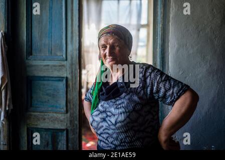 Ritratto di una vecchia donna nella sua vecchia casa ad Anig, Qusar distretto, Azerbaigian Foto Stock