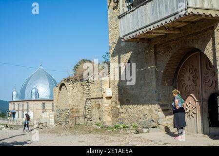 Una vecchia casa in Anig, Qusar distretto, Azerbaigian. Ci sono poche vecchie case ad Anig. Questi edifici hanno grandi cancelli di legno; presumibilmente, sono stati utilizzati per tenere cavalli. La gente usa solo la piccola porta nei cancelli e non apre mai i cancelli poichè non hanno più cavalli. Tali case hanno 2 piani, come tutte le case tradizionali nei villaggi di montagna nel quartiere di Qusar. Il primo piano è utilizzato per immagazzinare prodotti e conservare pollame, il secondo piano è un luogo di soggiorno. Foto Stock