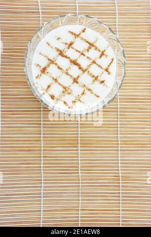 Riso alla cannella pudding riso pudding su bambù paglia stuoia come sfondo Foto Stock