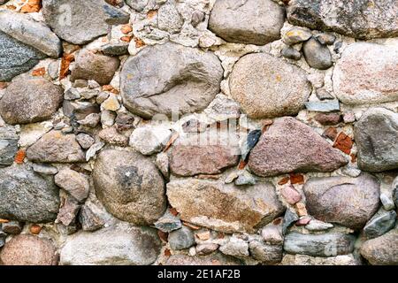 Vecchio muro di muratura di grandi ciottoli di granito. Foto Stock