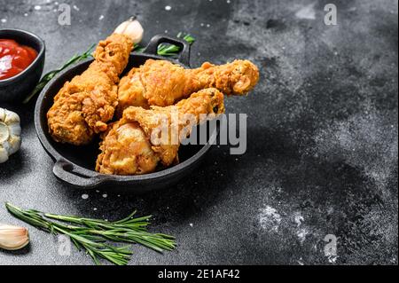 Bricioletti di pollo fritti piccanti e fritti profondi. Sfondo nero. Vista dall'alto. Spazio di copia Foto Stock