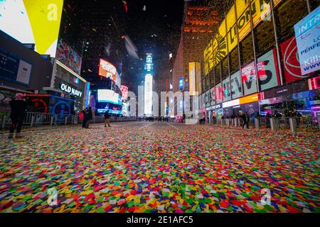 Un mare di confetti visto durante la palla di Capodanno cade in una Times Square quasi vuota a New York City.in media, circa un milione di rivelatori sono attratti dal Crossroads of the World per assistere alle performance e celebrare il nuovo anno. Quest'anno un pubblico dal vivo limitato di circa 40 soccorritori e lavoratori essenziali è stato autorizzato a guardare il lancio della palla di New Years da un'area sicura a Times Square. Foto Stock