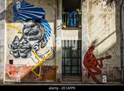 L'Avana, Cuba, luglio 2019, murale dell'artista di strada Caratoes che rappresenta la testa di una donna cubana e un chitarrista nella parte vecchia della città Foto Stock