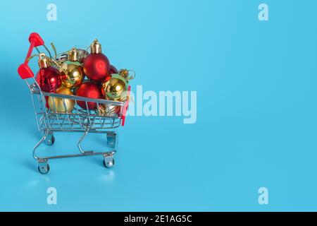 Un sacco di palle di Natale nel carrello della spesa. Acquistare gioielli per il nuovo anno e le vacanze di Natale Foto Stock