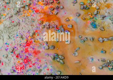 immagine astratta full frame che mostra vari spruzzi di vernice colorata su terreno fangoso Foto Stock