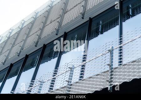 Edificio moderno con una facciata in metallo e vetro corrugato. Primo piano. Forme geometriche e riflessi Foto Stock