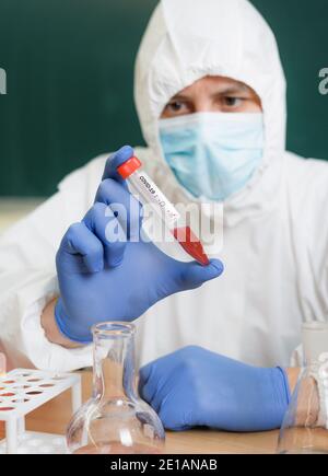 Un chimico in laboratorio studia il coronavirus in vitro Foto Stock