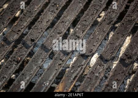 Un closeup delle barre di ferro da un carbone usato barbecue alla griglia Foto Stock