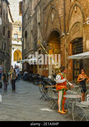 Giovane vestito con il costume tipico della Contrada della Selva in Via Diacceto, un vicolo stretto nel centro storico di Siena, Toscana, Italia Foto Stock