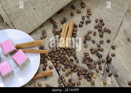 torte a base di ingredienti naturali, chicchi di caffè e cannella su un tavolo di legno. Foto Stock