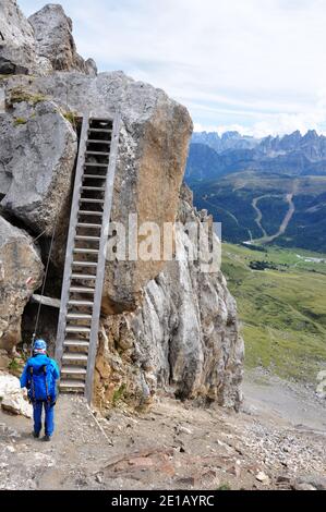 Salita in montagna esposta: Donna su scala in ferrata nelle Alpi italiane Foto Stock