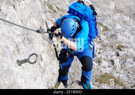 La ragazza sta salendo su via ferrata, Dolomity Foto Stock