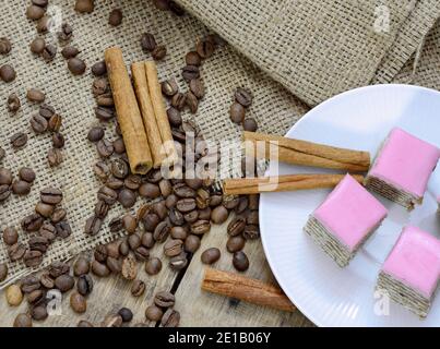 torte a base di ingredienti naturali, chicchi di caffè e cannella su un tavolo di legno. Foto Stock